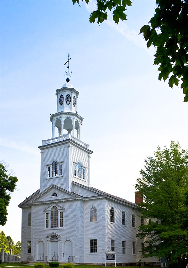 color photo of a white church building with steeple